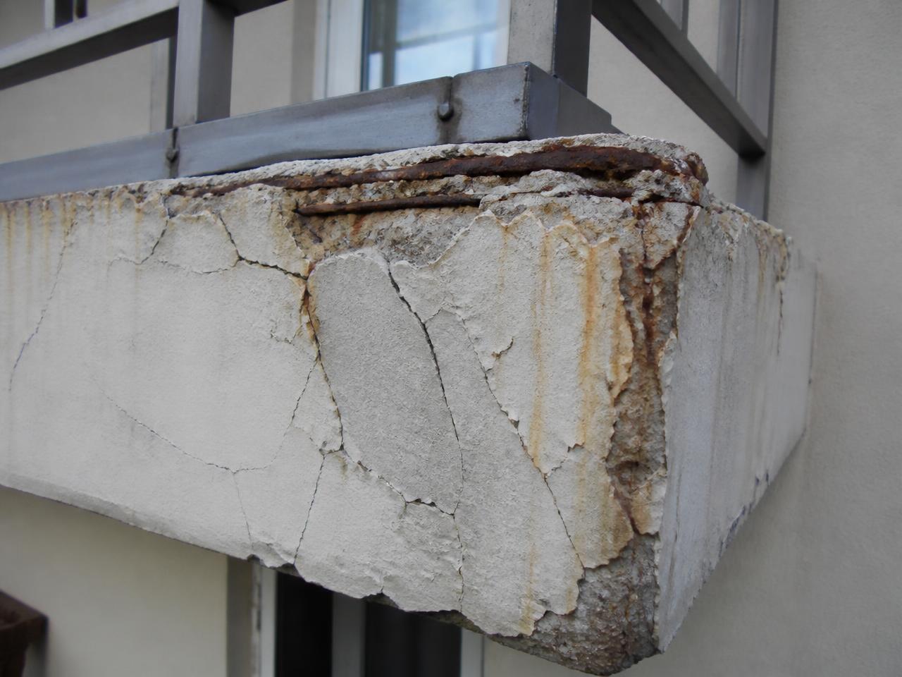 Spalling concrete balcony edge with exposed rusted reinforcement, a typical NEN 2767 defect